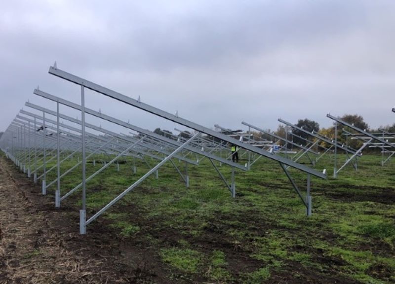 Gestell für einen PV-Park auf grüner Wiese.