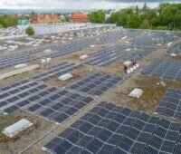 Luftaufnahem eines großen Flachdachs mit Photovoltaik und zwei Personen.