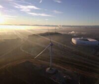 Luftbild mit Windenergie, der Allianz-Arena und Wolken über der Landschaft.