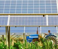 Ein Traktor fährt durch eine Photovoltaik-Anlage, Saxovent steigt in Agri-PV ein.