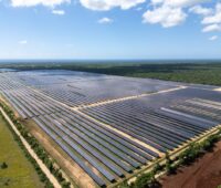 Luftbild einer Freiflächen-PV-Anlage in in der Dominikanischen Republik unter blauem Himmel.