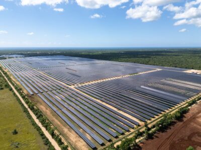 Luftbild einer Freiflächen-PV-Anlage in in der Dominikanischen Republik unter blauem Himmel.