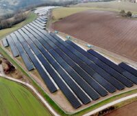 Luftbild zeigt PV-Freifläche von Wiesen und Äckern umgeben.