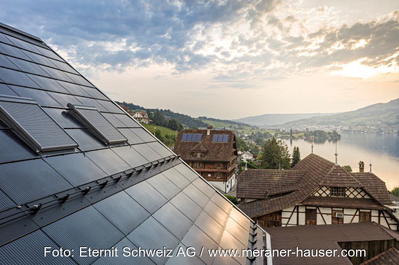 Eine dachintegrierte PV-Anlage in einem Dorf an einem Schweizer Bergsee.