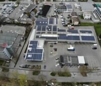 Zu sehen ist die größte Photovoltaik-Anlage Tübingens in einer Luftaufnahme, die die auf unterschiedliche Dächer verteilte Anlage zeigt.