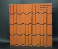 Auf dem Foto ist eine Folie zu sehen, die auf einer etwa quadratischen Fläche rote Dachziegel imitiert, der Hintergrund ist dunkelgrau.