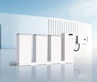 Mehere Batteriespeicher vom Typ SigenStack vor futuristischer Fassade.