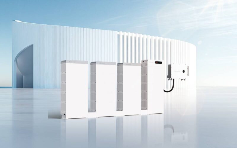 Mehere Batteriespeicher vom Typ SigenStack vor futuristischer Fassade.