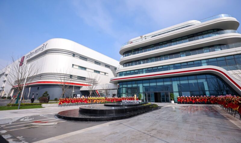 Blumen geschmückte Eingangsfront des neuen Fabrikgebäudes von Sigenergy in China zur Produktion von Speicher- und Wechselrichtern.