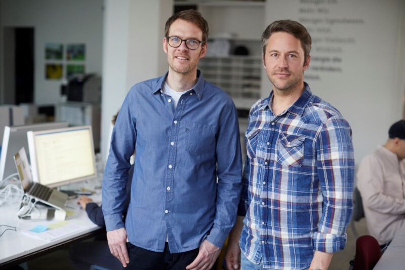 Die beiden Geschäftsführer von Polarstern Simon Stadler und Florian Henle stehend in Büroumgebung.