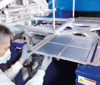 Bild zeigt Maschine zur Produktion von Solarzellen mit Monteur am linken Bildrand
