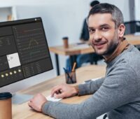 Zu sehen ist ein Mann vor einem Computer-Bildschirm, der das Onlineportal Solar-Log WEB Enerest 4 aufgerufen hat.