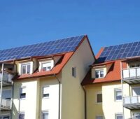 Zu sehen ist eine PV-Anlage auf einem Mehrfamilienhaus, symbolisch für Solarenergi in Großstädten.