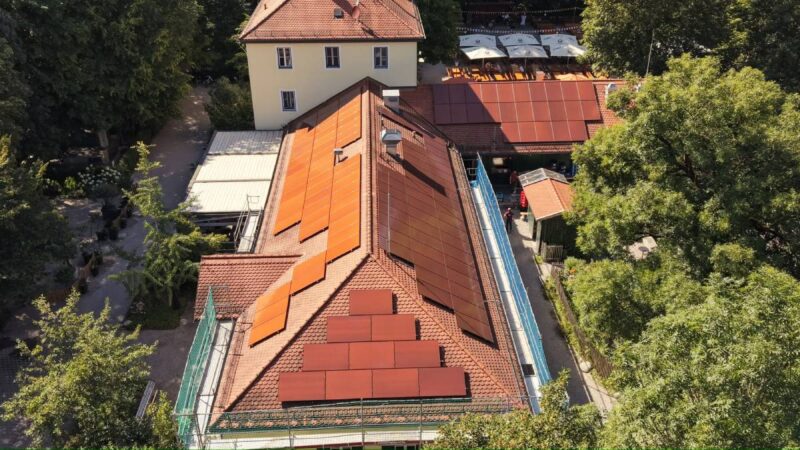 Kupferrote Solarmodule auf einem Dach mit Bieberschwanzschindelnim Englischen Garten Münchens.