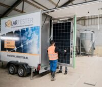 An einer mobiler Teststation überprüft ein SolarTester-Team ein Solarpanel auf Beschädigungen.