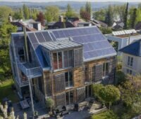 Im Bild ein Holzhaus mit Solardach, der Photovoltaik-Ausbau in Baden-Württemberg lag 2024 auf Rekordniveau.
