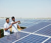 Zwei Männer in Photvoltaik-Anlage in Indien