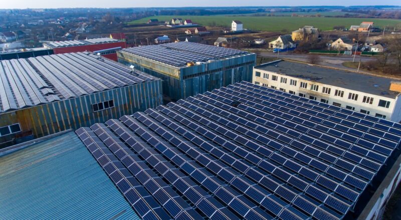 Blick auf ein Gewerbehallenflachdach mit einer Solaranlage.