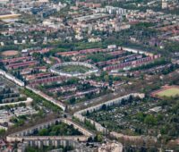 Zu sehen ist ein Luftbild von Neukölln. Im Rollbergkiez entsteht ein Quartier mit Solaranlagen und Saisonnalspeicher.