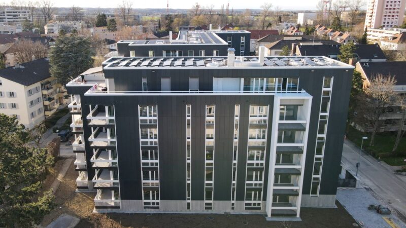 Mehrstöckiges Wohnhaus mit schwarzer Solarfassade