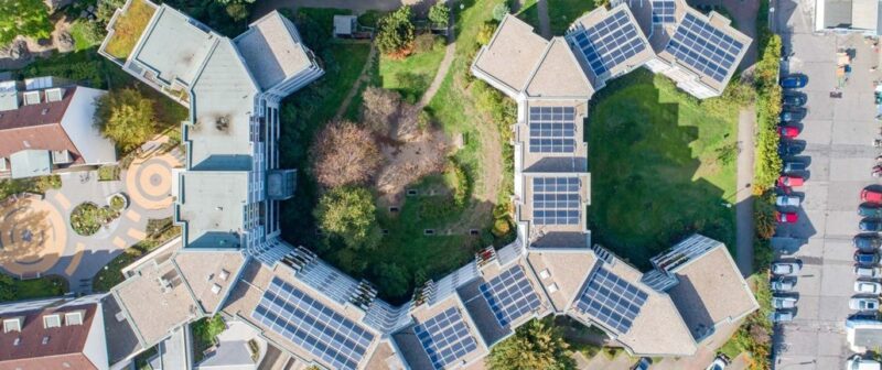 Zu sehen ist die Luftaufnahme einer Mieterstrom-PV-Anlage. Mieterstrom ist ein Baustein die Klimaziele im Gebäudebereich zu erreichen.