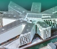 Im Bild ein Gebäudekomplex, das mit einer Photovoltaik-Anlage bestückt ist, die ein Montagesysteme vom Solarmontage-Hersteller Schletter nutzt.