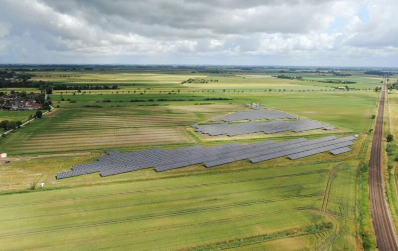 Luftbild eines Solarparks in Wiesen- und Ackerumfeld im Flachland.