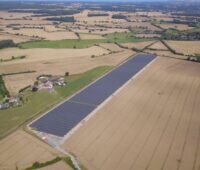 Luftbild eines Solarparks in einer Landschaft aus Feldern.