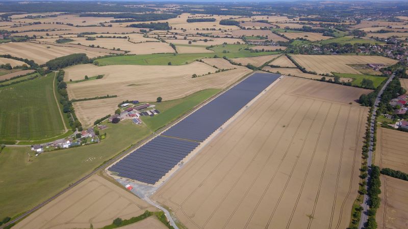 Luftbild eines Solarparks in einer Landschaft aus Feldern.