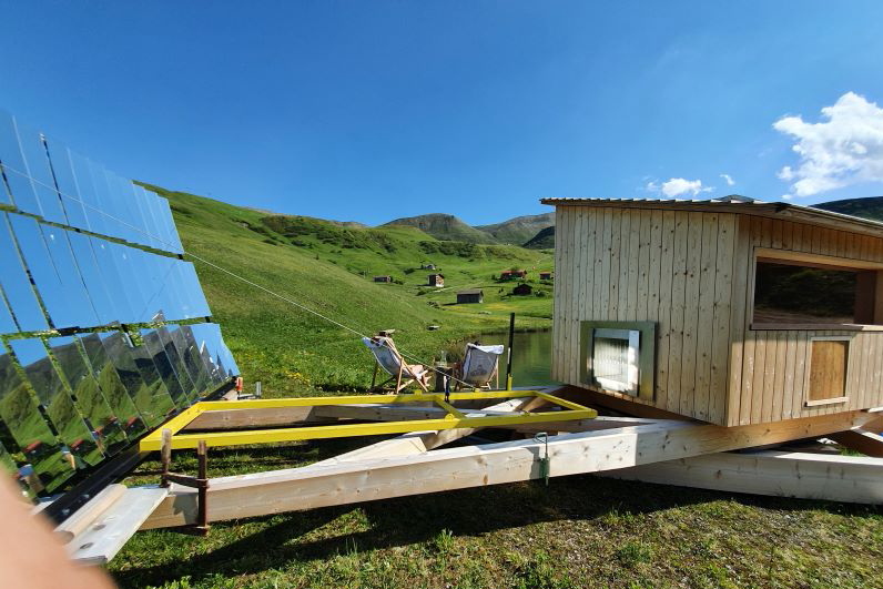 Solarkollektoren bündeln Licht auf Steine einer Außensauna.