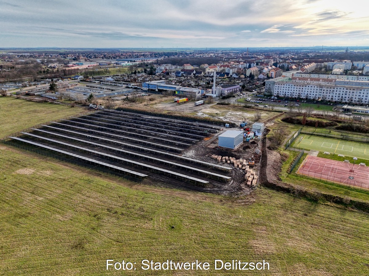 Luftbild zeigt Solarthermieanlage am Rande einer Gemeinde.