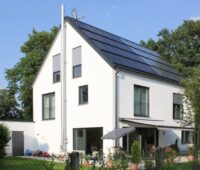 Moderne Solararchitektur im Sonnenhaus oder Solarhaus vereint Solarthermie und Photovoltaik.