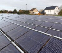 Solarthermieanlage für die Fernwärme in Lemgo. Im Hintergrund sieht man Wohnhäuser.