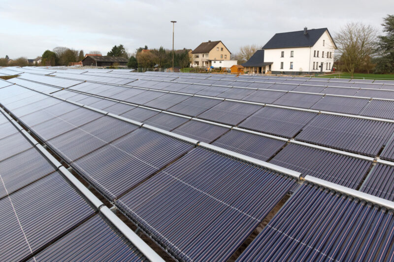 Solarthermieanlage für die Fernwärme in Lemgo. Im Hintergrund sieht man Wohnhäuser.