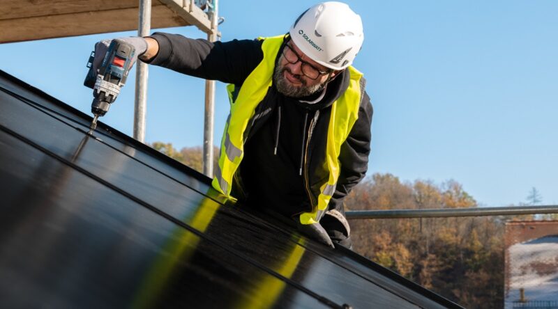 Im Bild ist ein Installateur, der PV-Module auf dem Dach befestigt. Laut Solarwatt-Marktstudie 2023 steigt das Interesse an der PV.