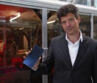 Mann mit Mini-Solarmodul in der Hand - Solarwatt-CTO Froitzhem mit TopCon-Modell.