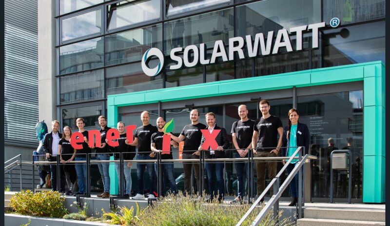 Im Bild eine Reihe von Menschen vor einem Solarwatt Gebäude, die den Schriftzug Enerix zeigen.