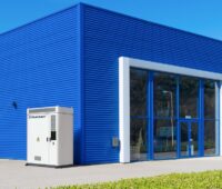 Der Gewerbespeicher von Solarwatt vor einer Fabrikhalle.