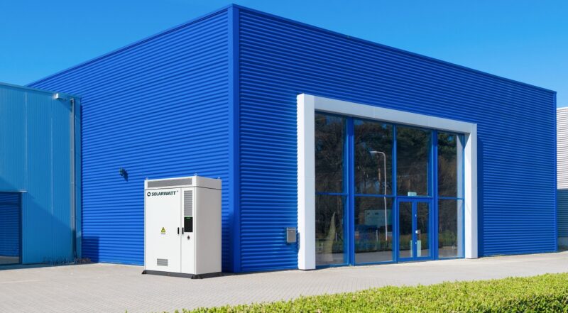 Der Gewerbespeicher von Solarwatt vor einer Fabrikhalle.