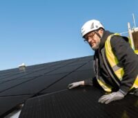 Zu sehen ist ein Mann bei der Photovoltaik-Montage, wie demnächst in Kassel für Solarwatt.