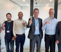 Sechs Männer mit Sektgläsern - die Geschäftsführer von Solarwatt und REConvert stoßen auf die Übernahme des Batterie-Herstellers an