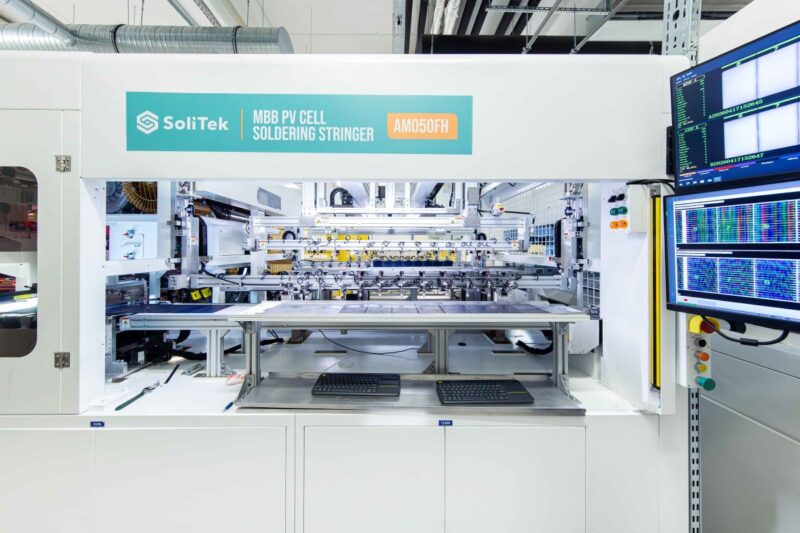Ein Stringer mit Aufschrift SoliTek fertigt Solarmodule in einer Fabrik