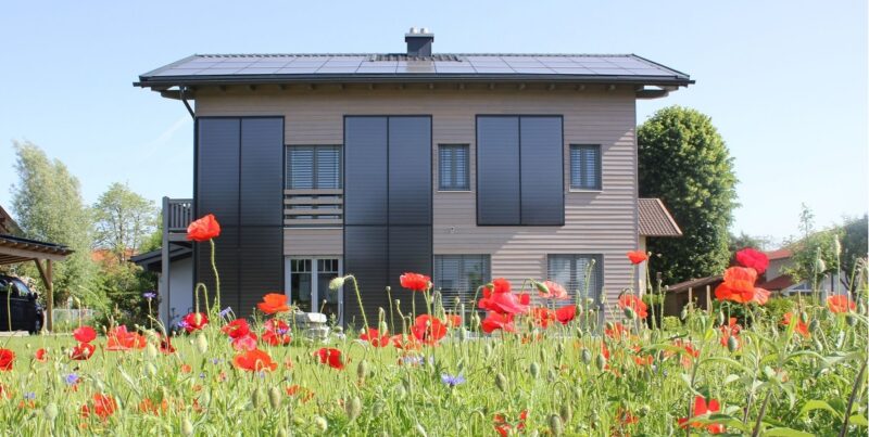 Zu sehen ist ein Gebäude mit Sonnenkollektoren an der Fassade. Die Einschätzung, dass Solarthermie nur auf geneigten Süddächern funktioniert, gehört ebenfalls zu den Irrtümern über die Solarthemrie.