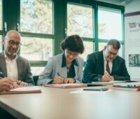 Drei Vertreter von Stadtwerken und Konsortium unterzeichnen einen Vertrag zur Umsetzung der kommunalen Wärmewende.