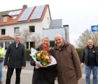 Zu sehen sind die Anlagenbetreiber Hanne und Dr. Bernd Rist mit Firmenvertretern vor ihrem Haus, das mit dem Solarpaket 20plus der Städtischen Werke Kassel umgerüstet wurde.