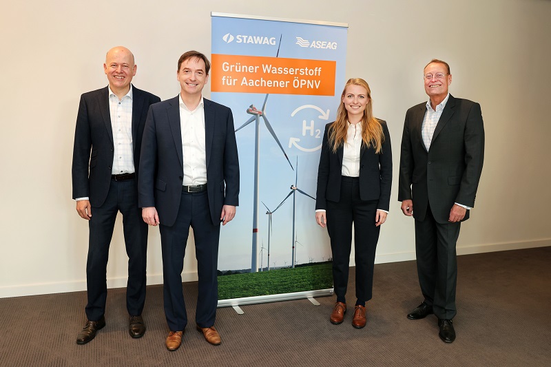 Zu sehen sind Firmenvertreter:innen von Stawag und Aseag bei der Vorstellung vom Elektrolyseur am Windpark Aachen Nord zur Wasserstoff-Herstellung.