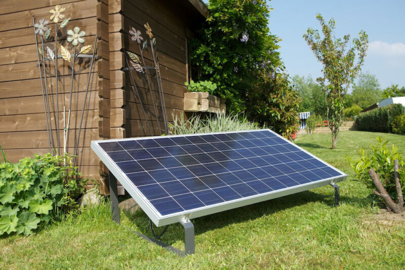 Stecker-Solar-Gerät vor Gartenhaus