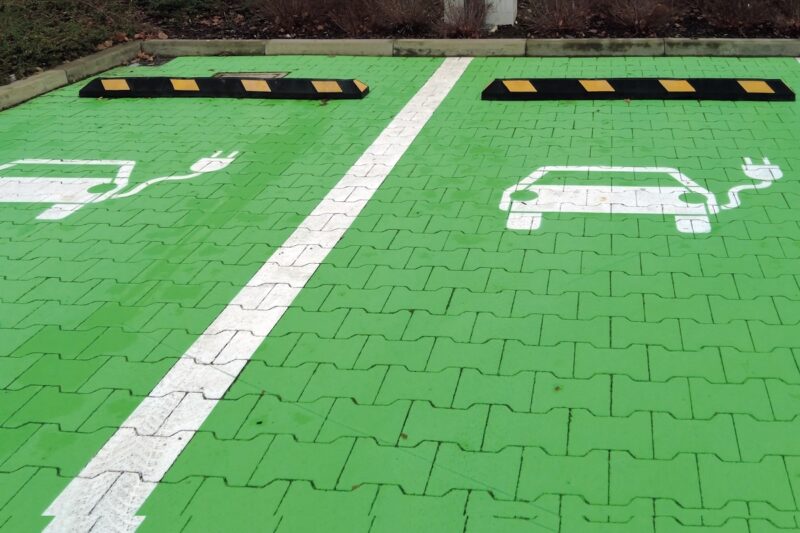 Grün eingefärbte Parkplatzflächen mit einem Symbol für Elektrofahrzeuge.