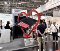 Messestand der Intersolar mit PV-Modul PV-Bondi und Besuchern.