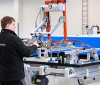 Sunmaxx-Mitarbeiter in Fabrikhalle an einem Arbeitstisch mit PVT-Modul.